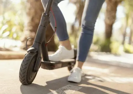 young woman rides electrical scooter city e1625741584575